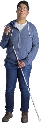 Patricia Overman, staand met blindengeleidestok